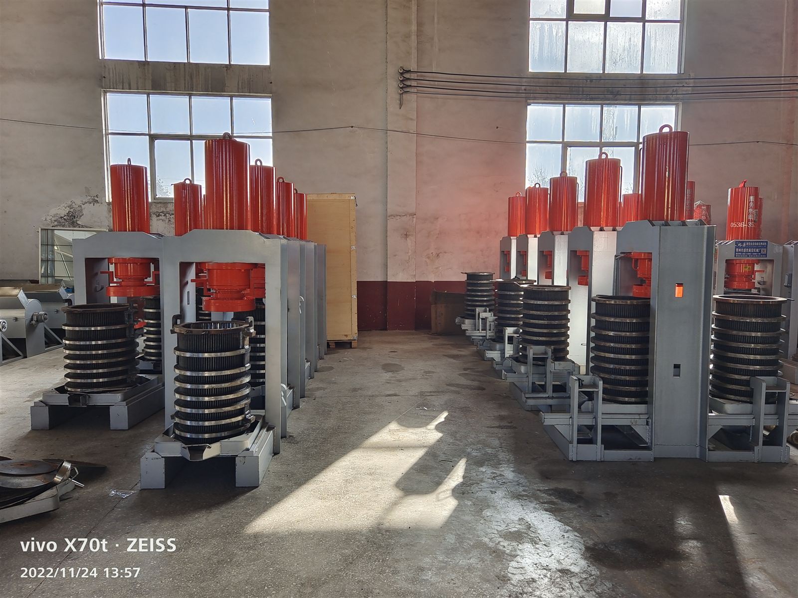 Two rows of vertical hydraulic presses in the finished goods area